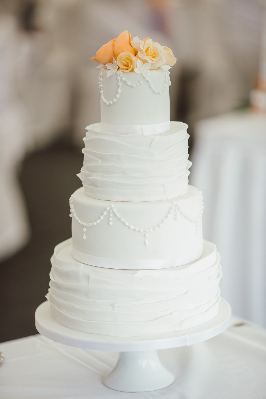 Vierstöckige weisse Hochzeitstorte mit Rüschen-Optik von Bäckerei Gassner